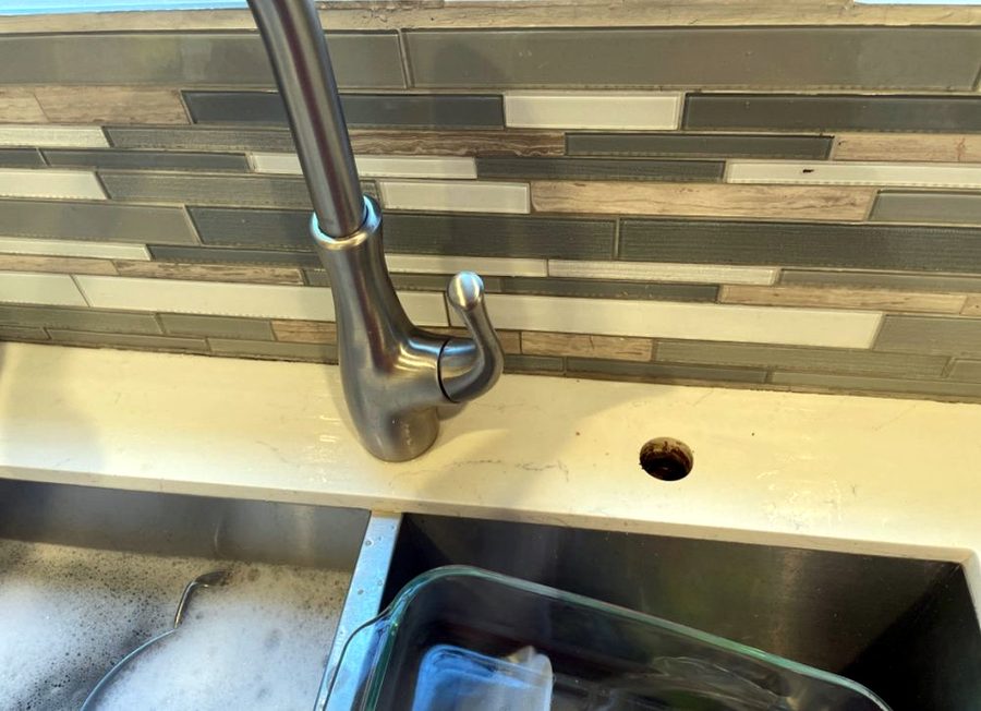 Brushed nickel pull-down kitchen faucet mounted on a sink deck