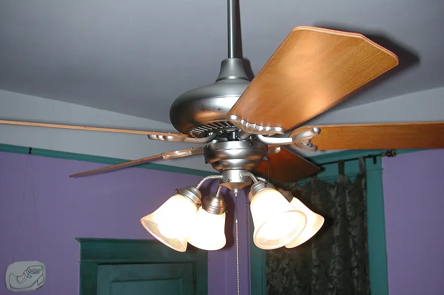 Ceiling fan with a light kit mounted in a high-ceilinged room