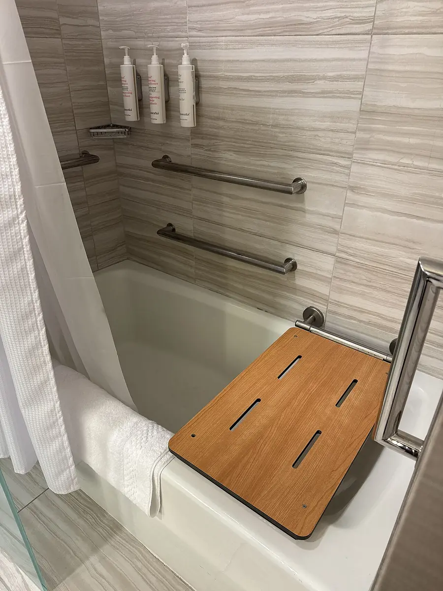 Shower with a fold-down bench and a horizontal grab bar
