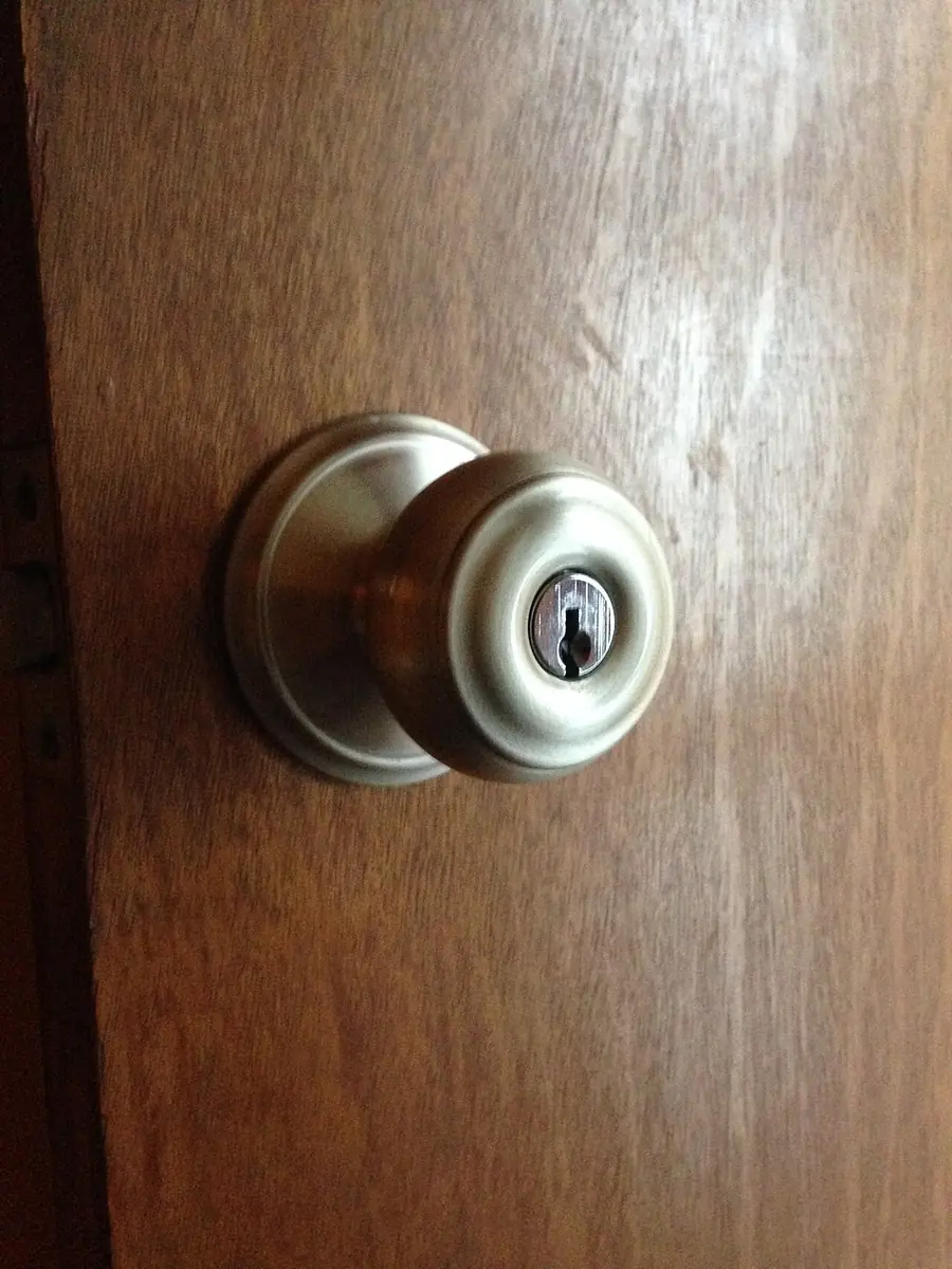 Brass doorknob with a key in the lock on a wooden door