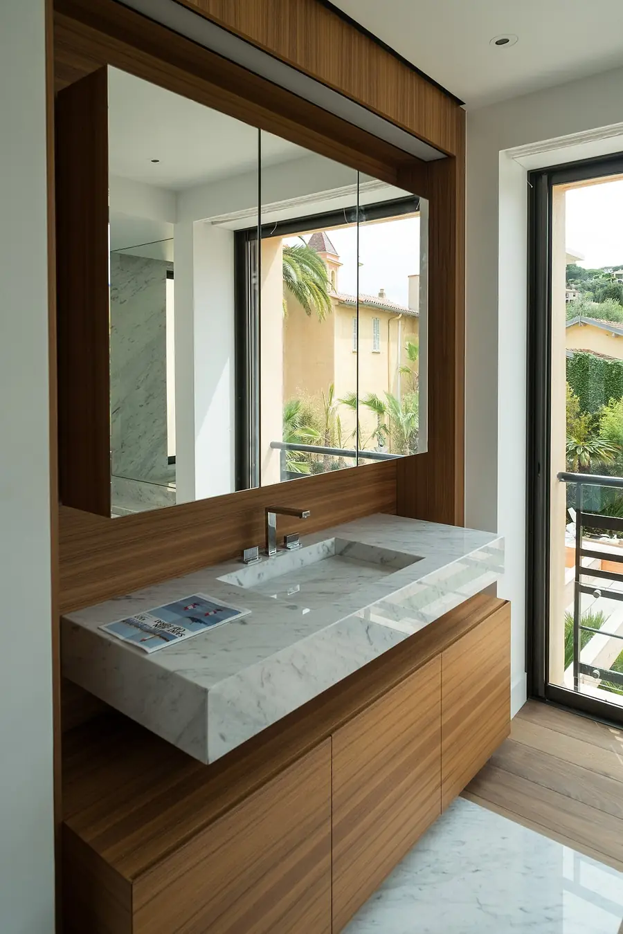 Vanity with a large framed mirror and lighting beside a bathroom window