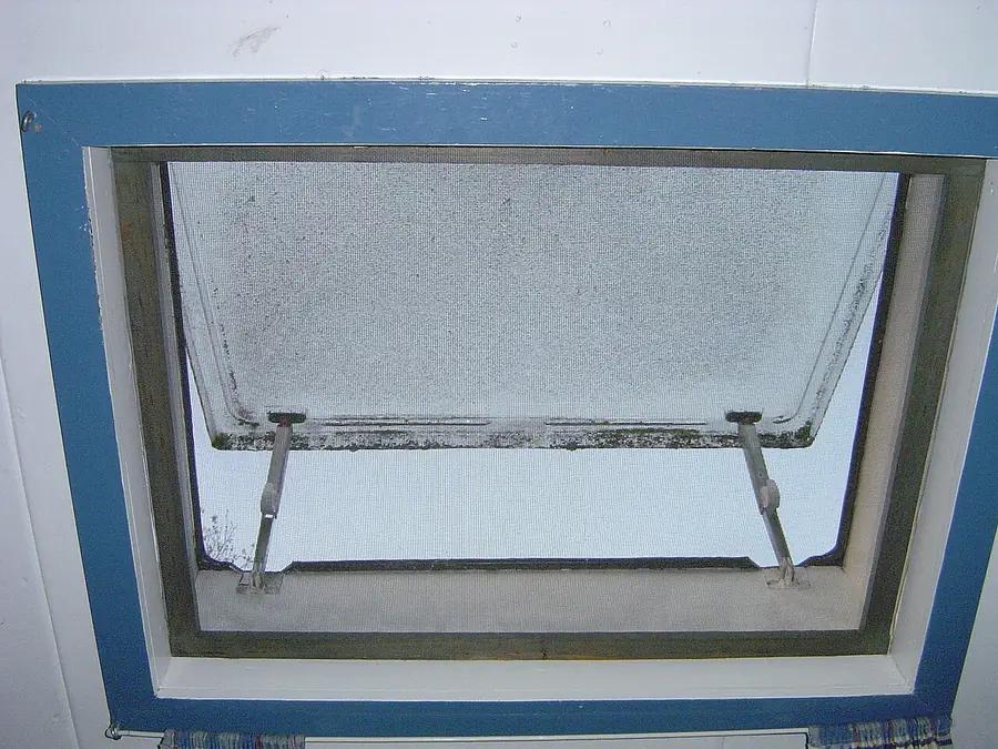 Open casement window with an aluminum insect screen frame, seen from inside