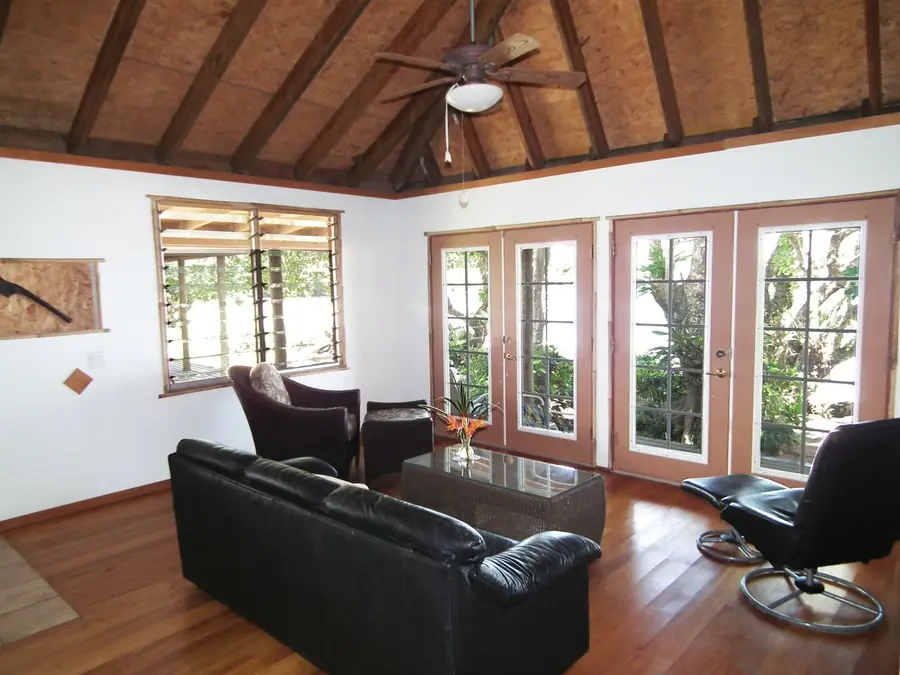 Ceiling fan with a light kit under a wood beam ceiling in a living room