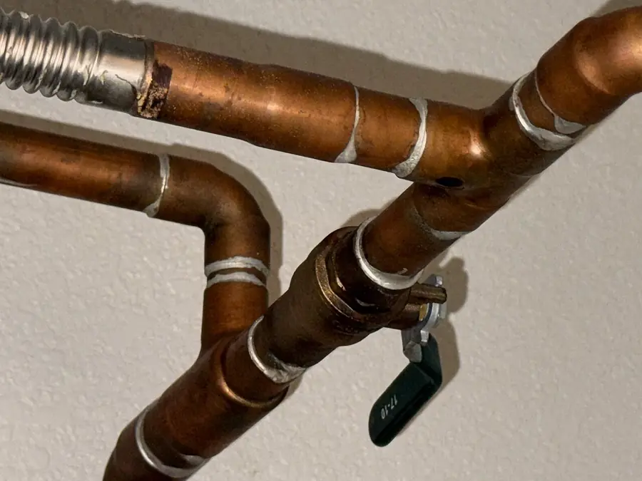 Copper water lines and a shutoff valve on top of a water heater