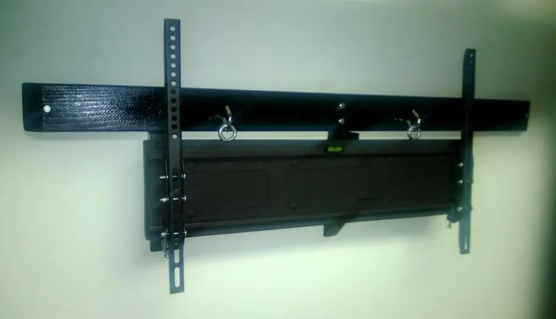 Black TV wall mount bracket screwed flat against a white wall
