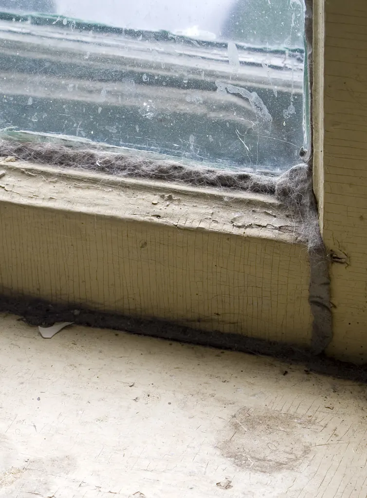Worn window sill with gaps and old sealant where drafts get in