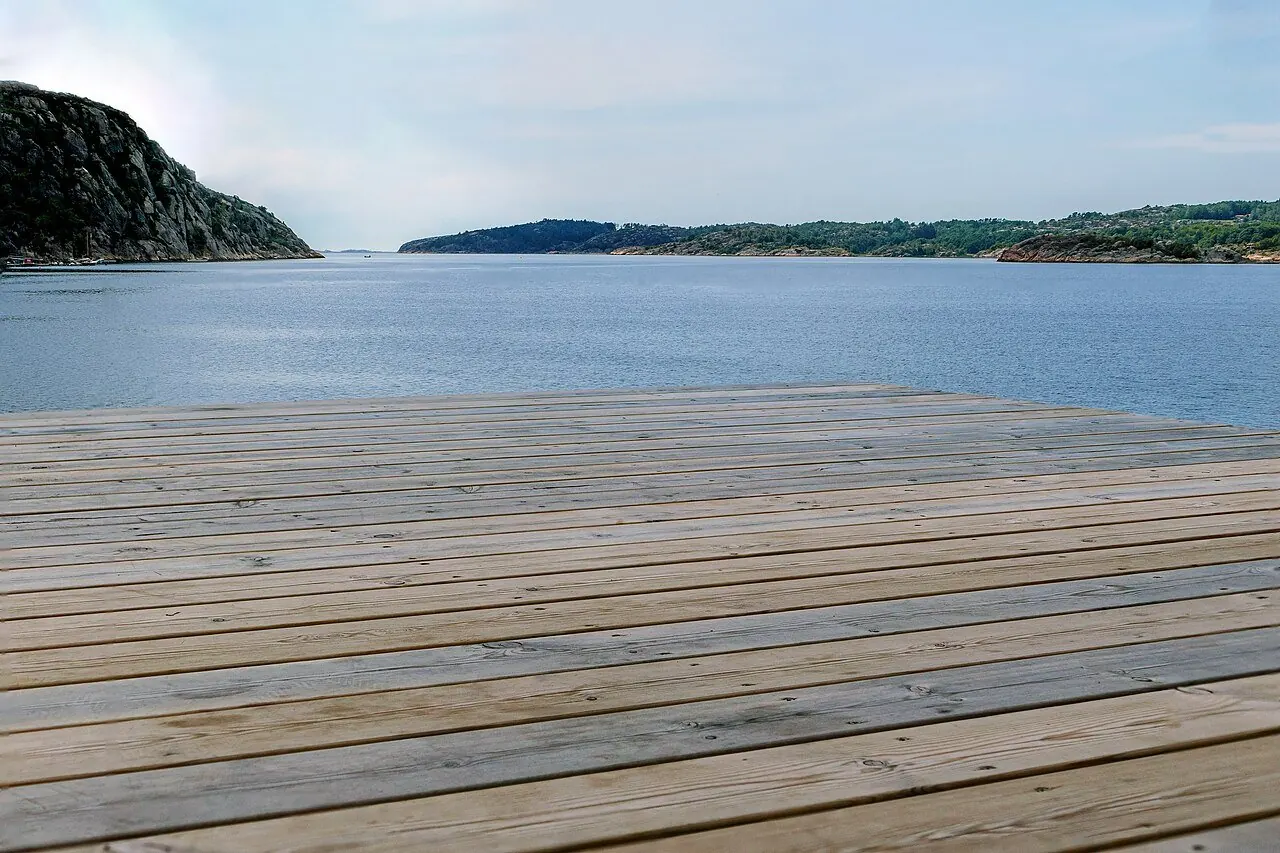 Weathered wooden deck boards and railing overlooking the water