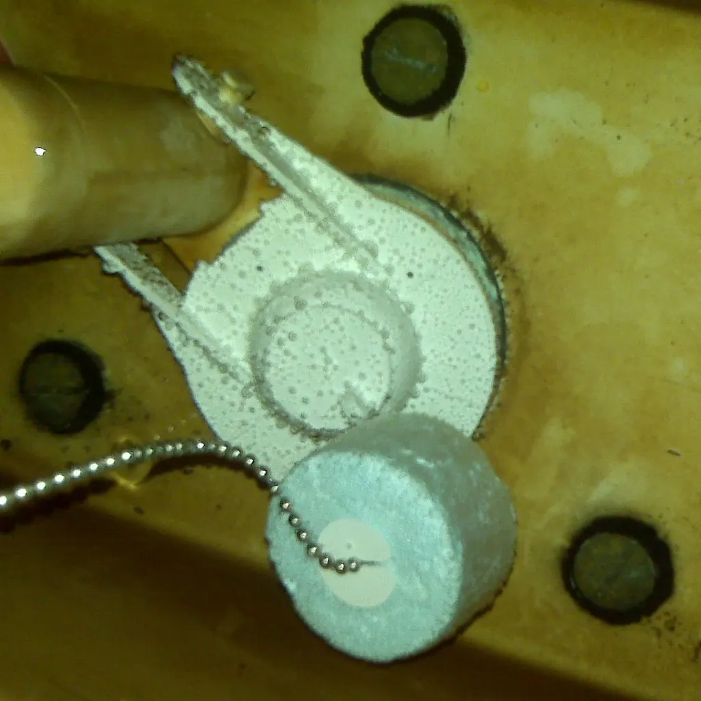 Toilet flapper and chain at the bottom of a tank