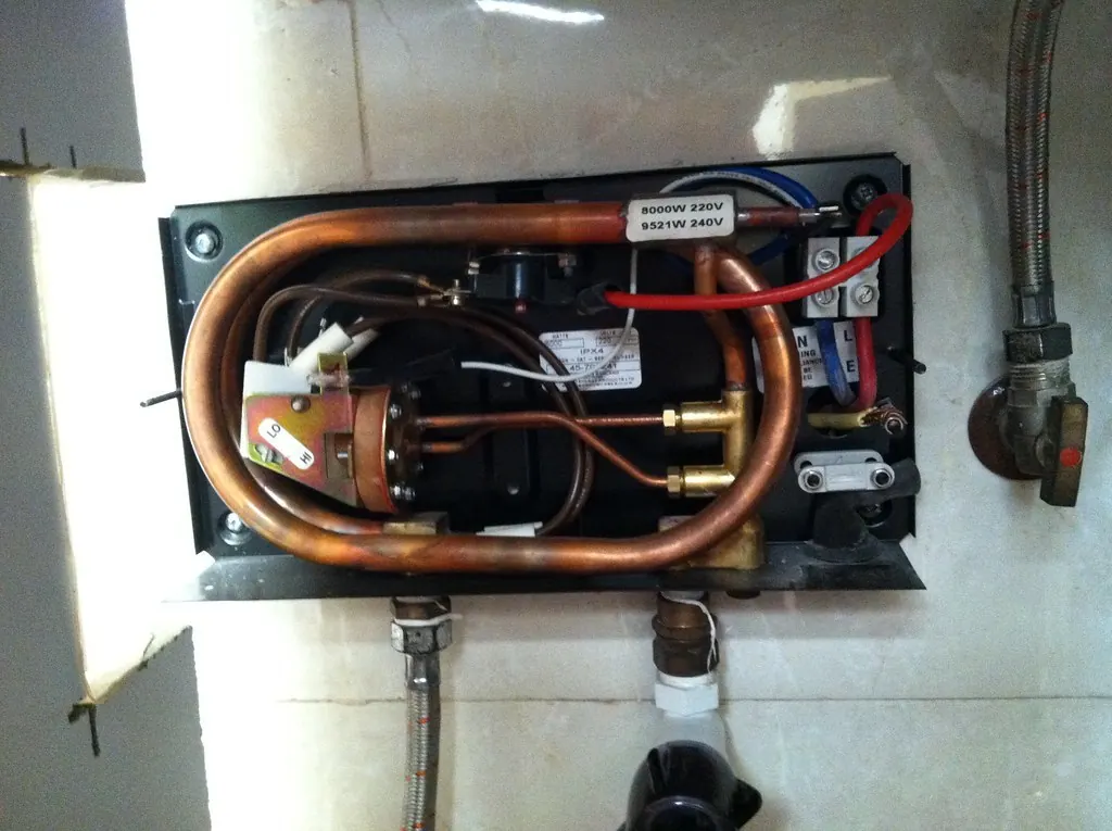 Open tankless water heater showing its copper heat exchanger