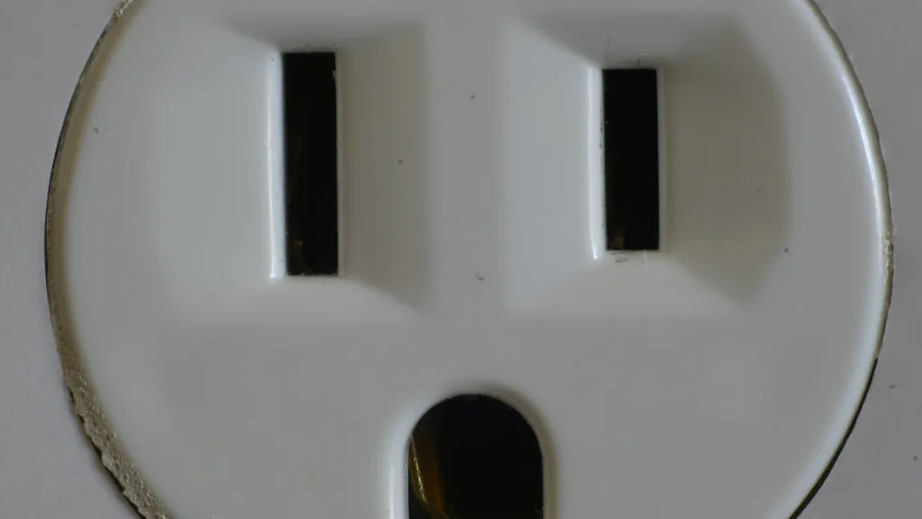 Close-up of an old two-prong-plus-ground wall outlet