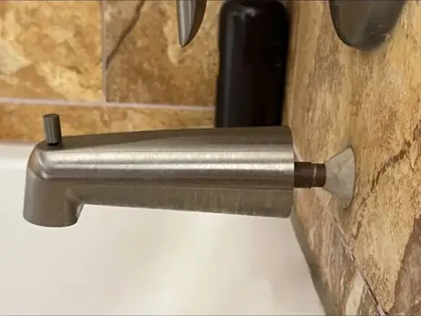 Brushed tub spout installed against a stone wall