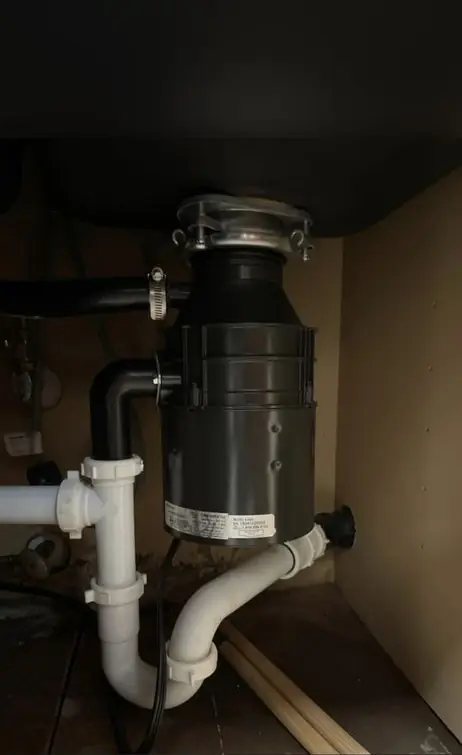 Disposal and PVC drain piping under a kitchen sink