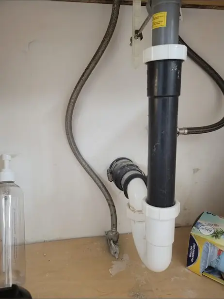 New drain elbow and trap under a kitchen sink