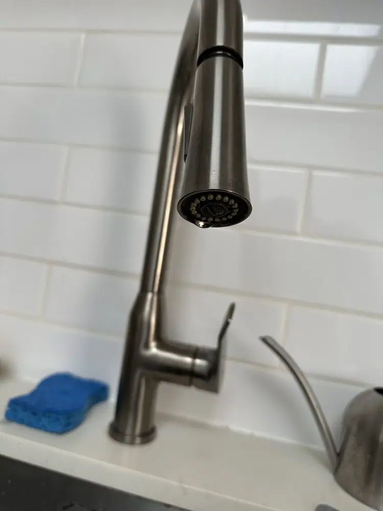 Brushed-nickel pull-down kitchen faucet over a white sink