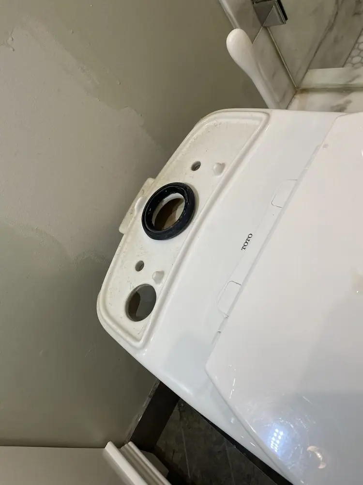 Toilet tank with a new tank-to-bowl gasket during a repair