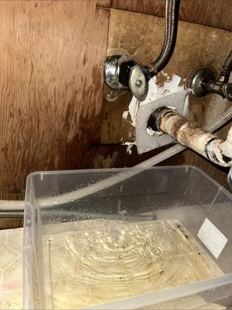 Section of copper supply pipe being replaced under a sink