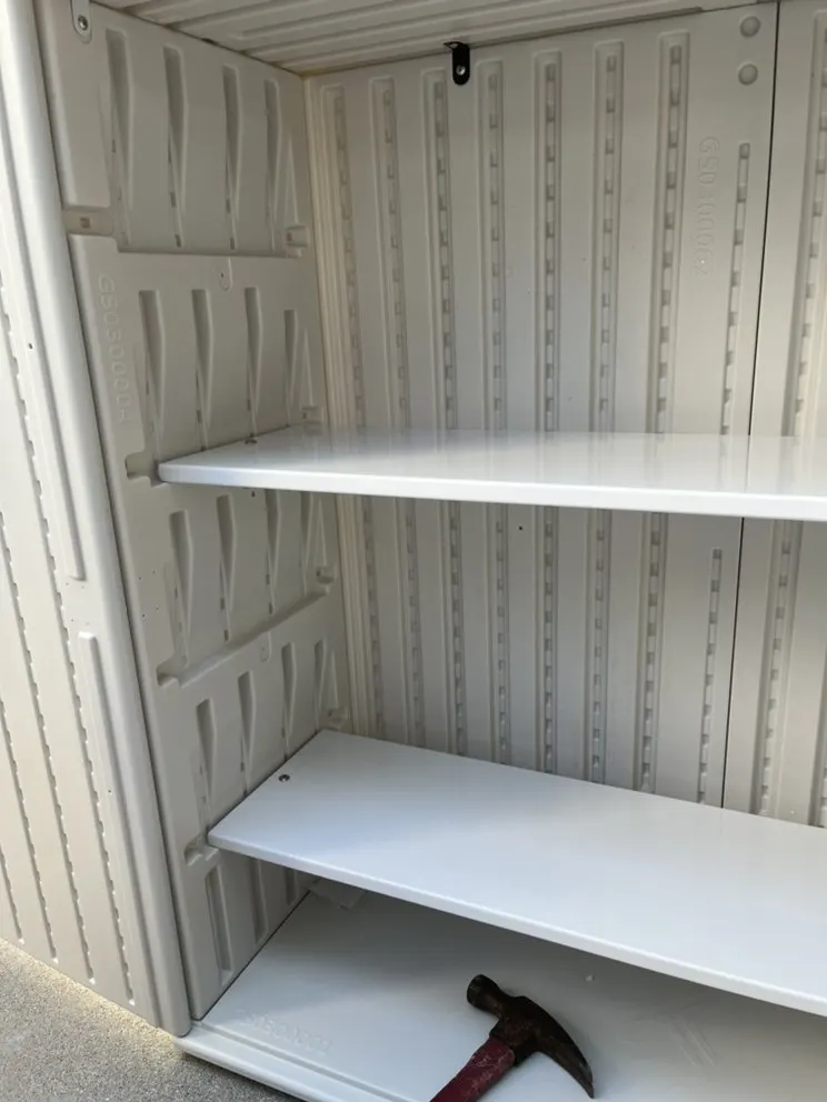 White wood shelves installed level inside a storage closet with patterned walls